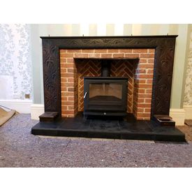 Brick lined fireplace with an antique oak surround