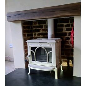 Jotul F100 in ivory enamel - 5kw woodburner. Above it is a geocast dark oak effect beam. 