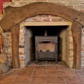 Clearview Vision 500 8kw stove in a brick fireplace with character oak surround