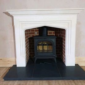 Stovax Huntingdon 35 with tracery door. Honed granite hearth. Brick lined recess. Limestone mantel. 