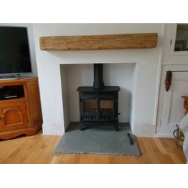 Hunter herald 5 double door stove. Focus cast character deep beam in pale oak effect. Grey limestone flagstone hearth. 